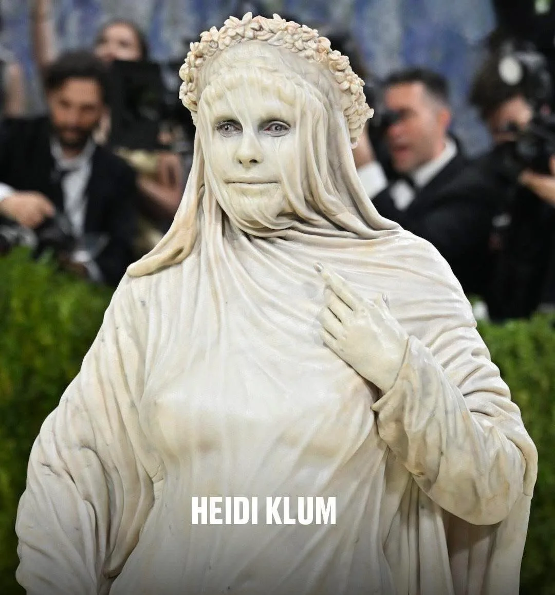 Heidi Klum dressed as a marble statue — high-art pretense for a $100,000 ticket.